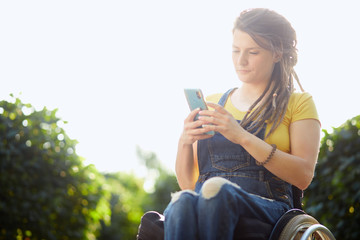 attractive hipster girl using her smart phone while resting in the gardern. close up portrait. copy space.lifestyle, spare time, leisure activity