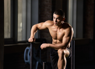 Fototapeta na wymiar Portrait of handsome muscular bodybuilder smiling in modern gym