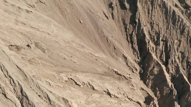 Cinematic shot aerial drone view of small volcanic ash fall from Mount Bromo crater with in East Java, Indonesia