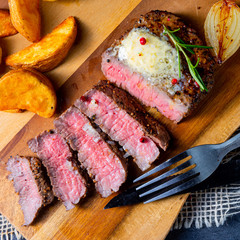rustic medium butter beef steak with herbs and potato wedges