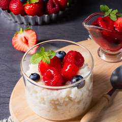 delicious milk rice with different berries and red fruit jelly