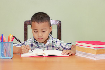 Children go back to school. Little thinking boy doing homework at home.