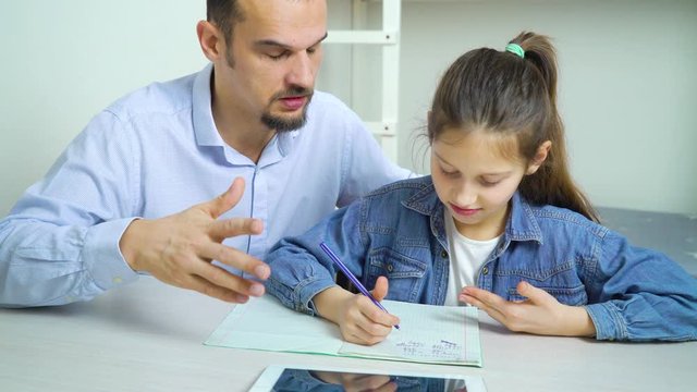 private tutor helping little school girl with studies