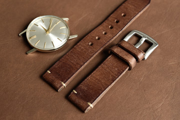 Dark brown leather watch strap with stainless buckle on leather background, Craft and handmade watch bracelet, Luxury classic and vintage style.