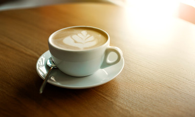 Cup of hot cappucino on the wooden table. Early morning breakfast