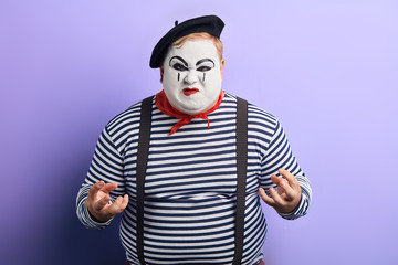 I'll kill you. agressive clown being hysterical. close up photo. isolated blue background, studio...