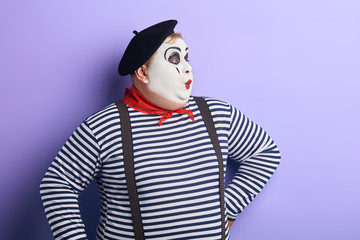 Pantomime actor with hands on the hip performing on the stage. close up portrait, isolated blue...