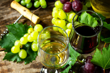 Wine concept. White and Red wine in glasses, bottle, grapes on vintage background.