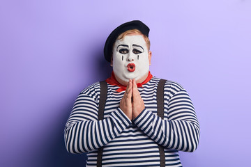 emotional sad unhappy artist keeps palms under chin, asking to help him. isolated blue background, studio shot. body language