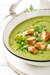 Pea soup. Green pea puree soup in a bowl served with grilled toasts, top view