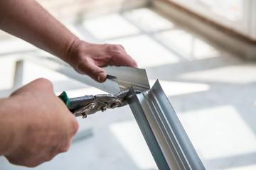Male worker works with profile for drywall, marker marks for cutting. Construction work, repair....