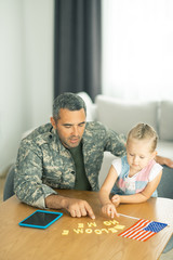 Fototapeta na wymiar Military man coming back home and playing with daughter