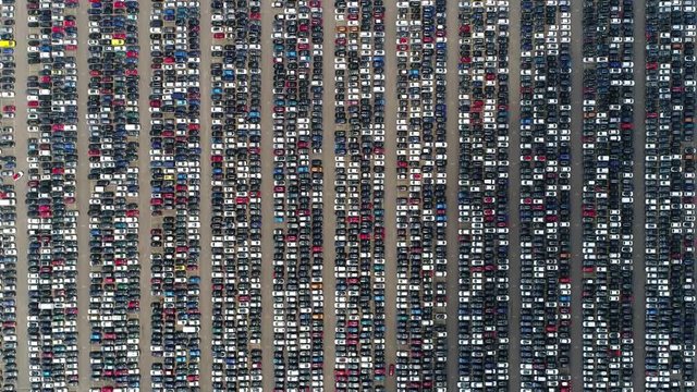 Aerial top down view of automaker distribution center with new vehicles perfectly lined up next to each other ready for further transportation retailers and dealerships 4k high resolutions footage