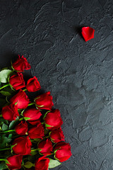 Red roses on a black textured background. Place for text, top view