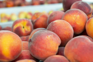 Fototapeta na wymiar Fresh raw ripe juicy sweet peaches sold on outdoor market. Farm seasonal spanish fruits and vegetables