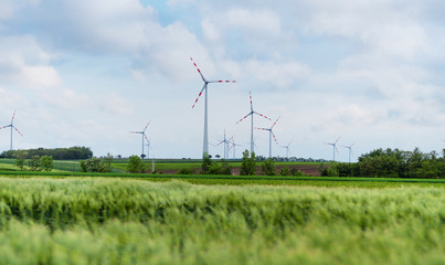 Wind turbine on green fields in summertime. Natural wind power plants and sustainable eco-friendly energy resources