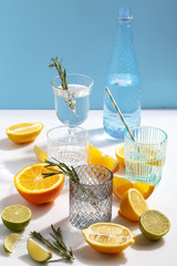 Composition of glassware and cut citrus fruits on a white background. The concept of making homemade lemonade.