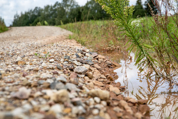 Flooded, muddy country road after rainfall and storm. Natural disaster and consequences of global warming