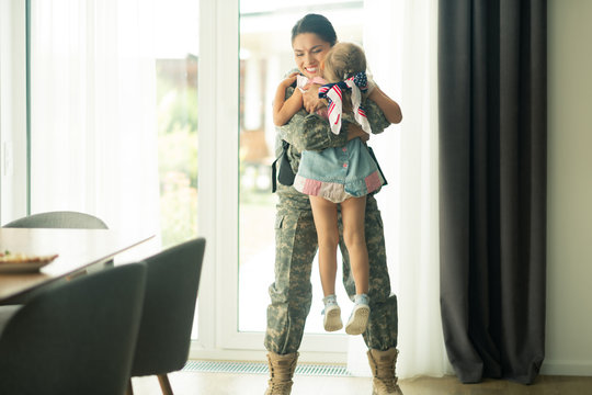 Woman Lifting Her Little Daughter While Coming Back Home