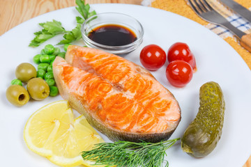Grilled piece of arctic char with canned vegetables and seasoning