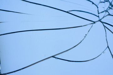 Broken mirror with fragments and cracks close-up.