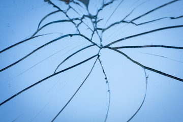 Broken mirror with fragments and cracks close-up.