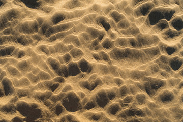 Footprints left in the sand of the beach by the waves when the tide is low.