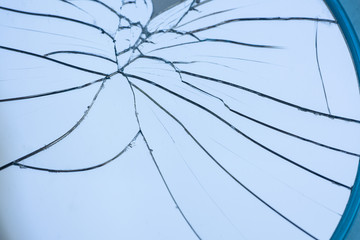 Broken mirror with fragments and cracks close-up.
