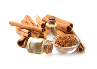 Aromatic cinnamon sticks and essential oil on white background
