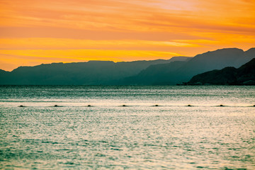 Fototapeta premium Sunset over the Red Sea in Eilat, Israel. Beautiful evening sea landscape. View of the sea and mountains