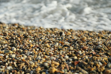 Small sea stones, stones on the beach, vacation at sea, pebbles seashore. Background. Texture.