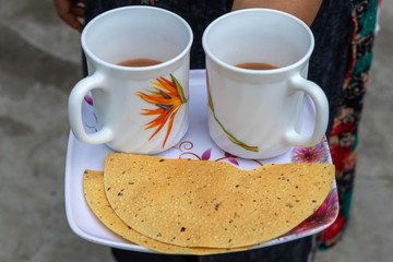 Tea with papad, woman serving indian tea in white cups with papad snake.