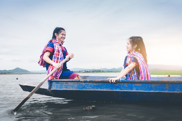 Beautiful Asian girls on fishing boat in lake to catch fish at countryside of Thailand