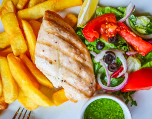 Grilled chicken with french fries and vegetables