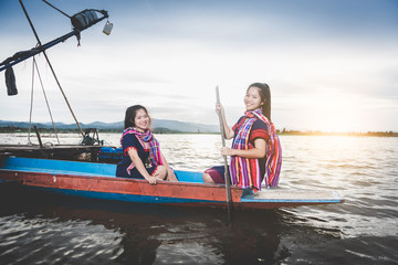 Beautiful Asian girls on fishing boat in lake to catch fish at countryside of Thailand