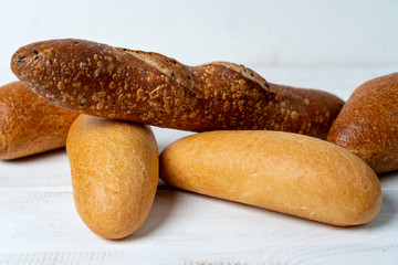 different mini baguettes on white wooden table