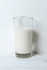 glass of milk on white wooden table