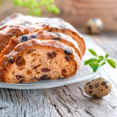 Close-up on Easter bread on rustic wood with fresh leaves and quail eggs. Traditional German dessert for Easter celebration