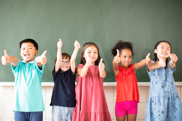 Multi-ethnic group of school children standing in classroom