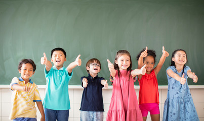 Multi-ethnic group of school children standing in classroom