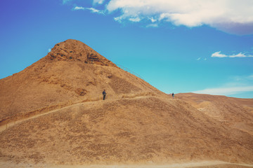 Fototapeta na wymiar Desert landscape. A man stands on a hill. Climbing Masada from the west