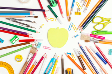 Naklejka premium Back to school concept with apple note and school supplies on white background. Copy space, top view.