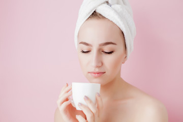Portrait of beautiful girl in bathrobe with a cup of tea, relaxation concept blonde woman wearing...