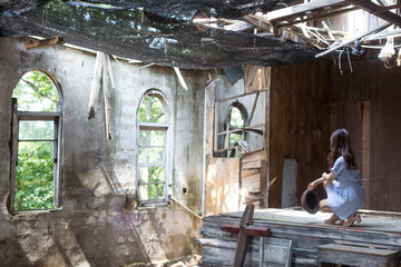 Woman inside the old abandoned church. sunny day window