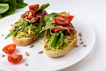 Snack sandwiches with jamon, avocado, tomatoes and leaf salad.