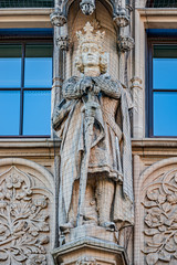 Fototapeta na wymiar Wall figures of king and queen protected by fishnet at main facade of Justice Department in Magdeburg, Germany, closeup, details