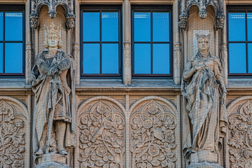 Wall figures of king and queen protected by fishnet at main facade of Justice Department in Magdeburg, Germany, closeup, details
