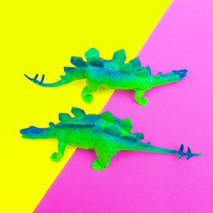 Plastic two green dinosaurs on colored background. Minimal flat lay art.