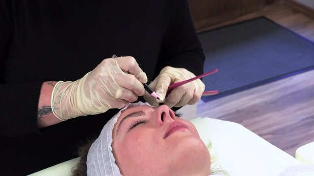 Young girl make permanent makeup. Eyebrow Microblading