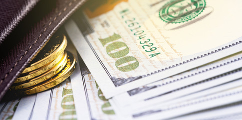 closeup stack metal coins, hundred dollars banknotes in wallet